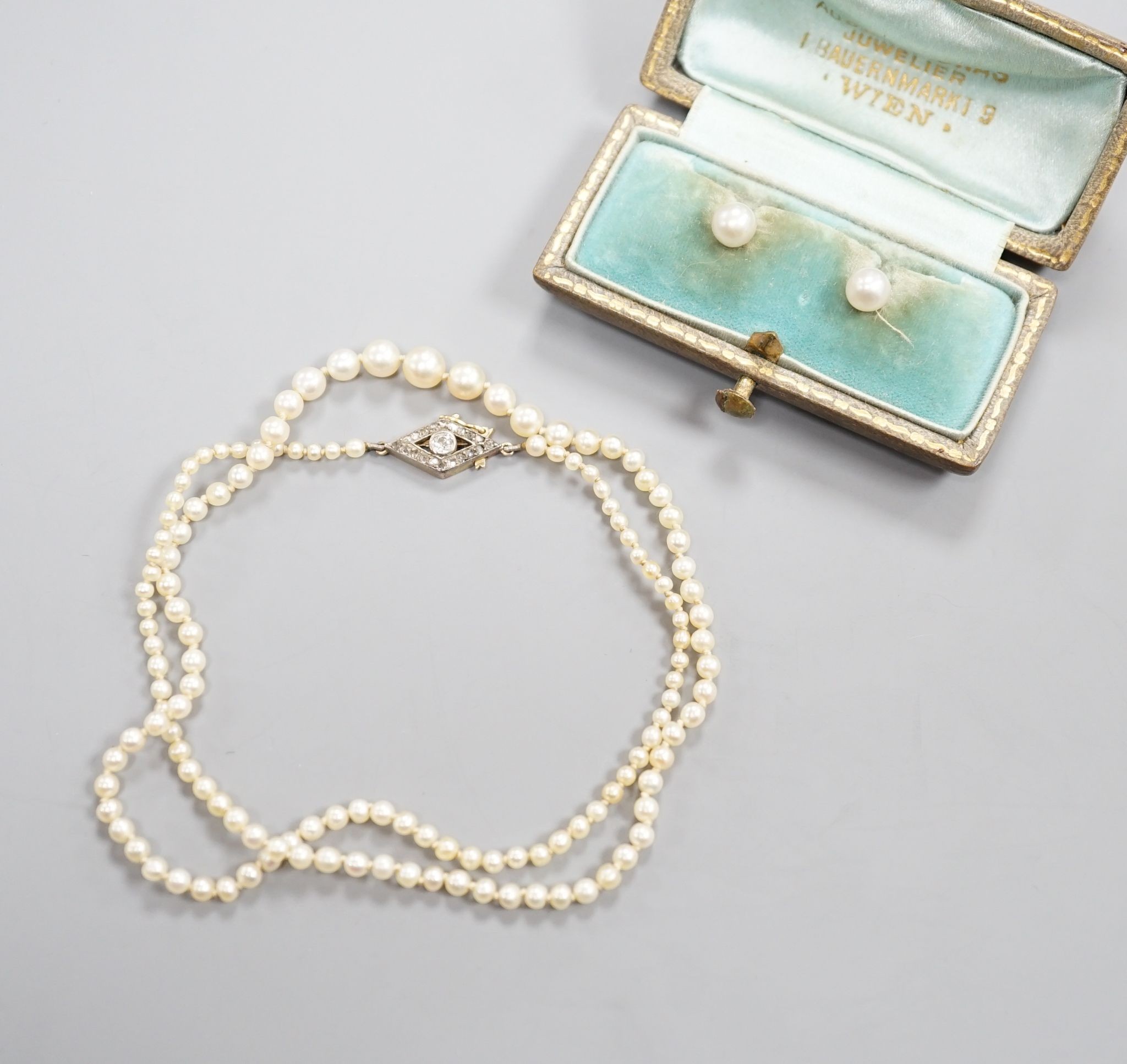 A single strand graduated seed pearl necklace, with yellow metal and diamond set clasp 42cm and a cased pair of similar Austro Hungarian ear clips.